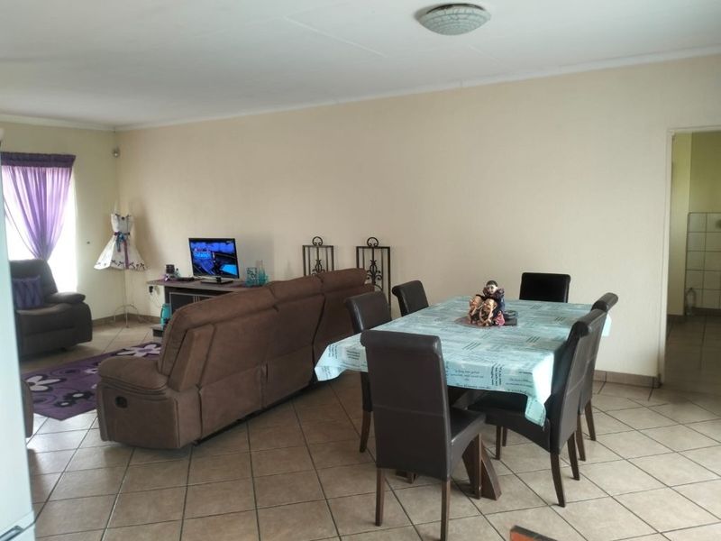 Open plan living and dining area featuring neutral wall finishes and ceramic floor tiles throughout.
