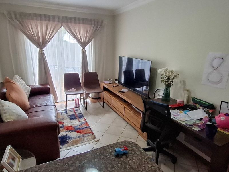 A living room featuring tiled flooring and a sliding glass door providing access to the exterior.