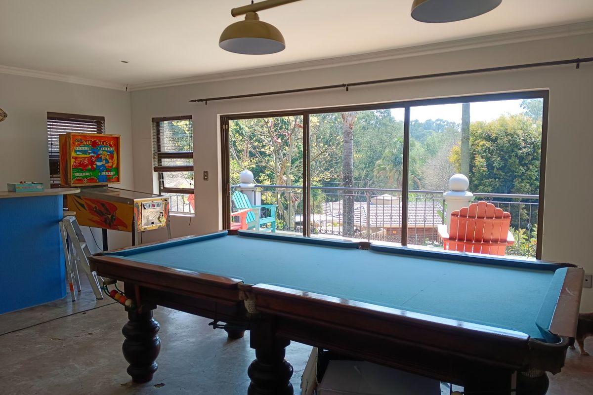 Spacious living area featuring large sliding glass doors that open to a balcony, providing ample natural light and views of the surrounding greenery.