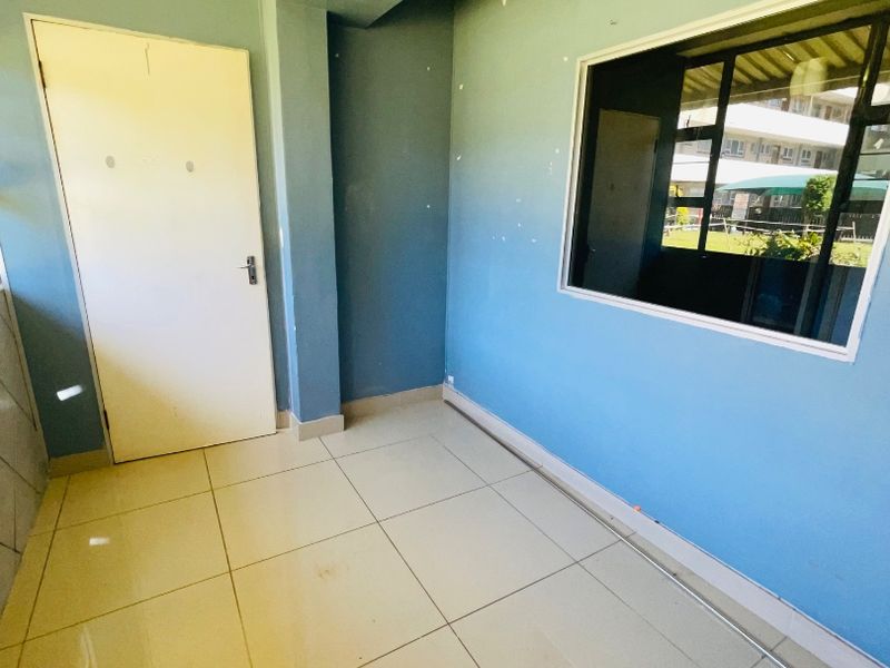 An empty bedroom featuring tiled flooring and blue painted walls, offering a blank canvas for potential interior design updates.