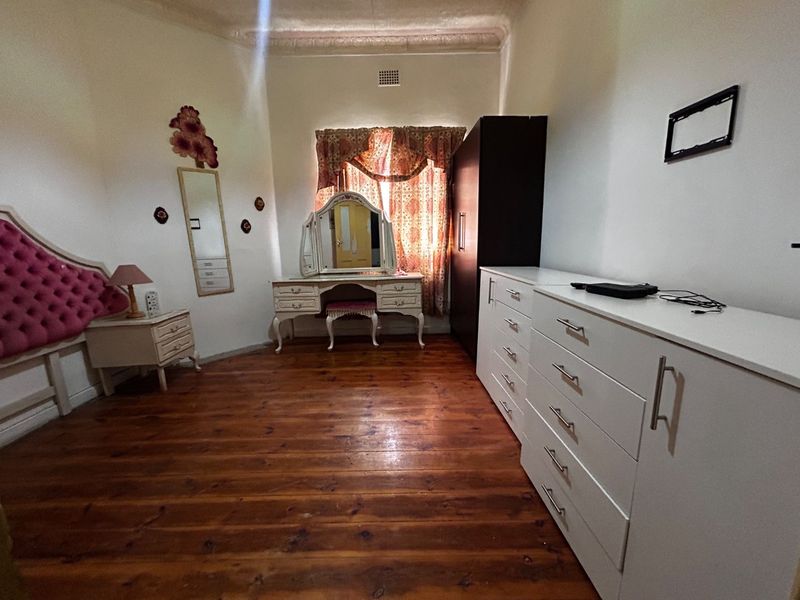 A bedroom featuring original timber flooring and decorative ceiling cornicing, offering a classic foundation for potential interior updates.