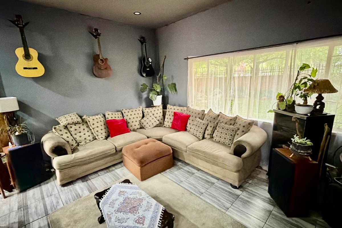 A living room featuring tiled flooring, recessed downlighting, and a large window providing natural light.
