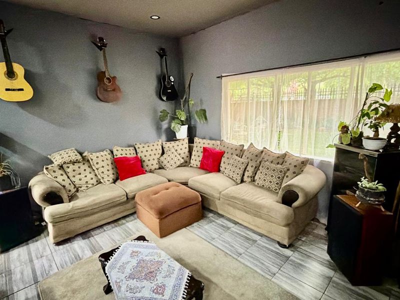 A living room featuring tiled flooring, recessed downlighting, and a large window providing natural light.
