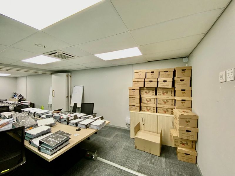 A functional commercial office space featuring a suspended ceiling, recessed lighting, integrated air conditioning, and built-in storage cabinetry.