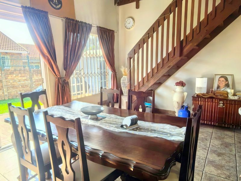 Dining area featuring tiled flooring, a wooden staircase, and a sliding glass door providing access to the outdoor patio area.
