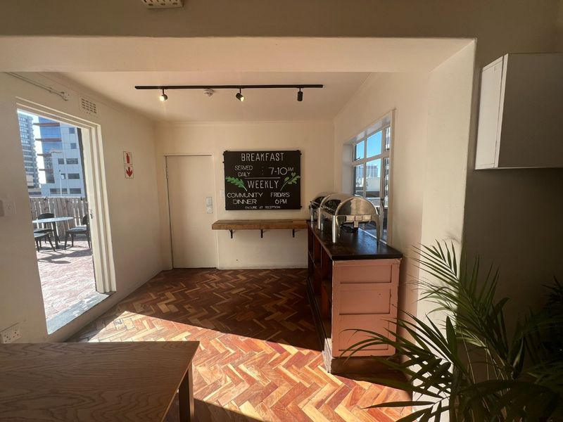 Open-plan area featuring herringbone parquet flooring, track lighting, and direct access to an outdoor patio space.