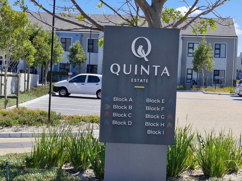 Entrance view of Quinta Estate featuring a clear directory sign, paved parking bays, and well-maintained landscaped garden areas.