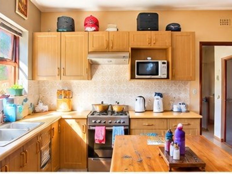A functional kitchen featuring wooden cabinetry, a double basin sink, a gas stove with extractor fan, and a built-in microwave.