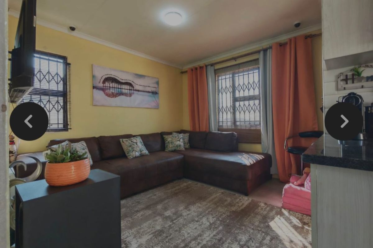 A cozy living room featuring security bars on the windows and neutral wall finishes, providing a functional and secure living space.