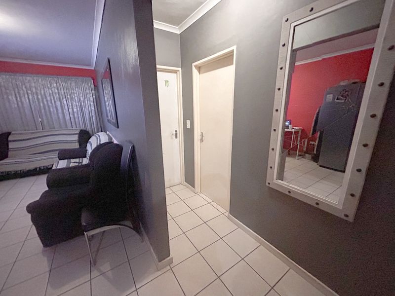 A tiled hallway area connecting living spaces with neutral grey wall finishes and standard internal door access.