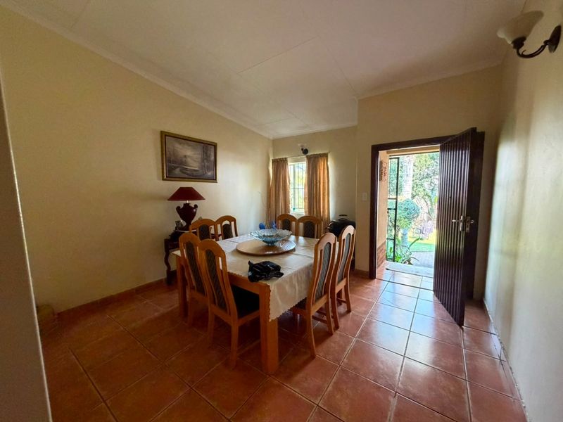 A dining room featuring tiled flooring and direct access to the outdoor area through a single door.