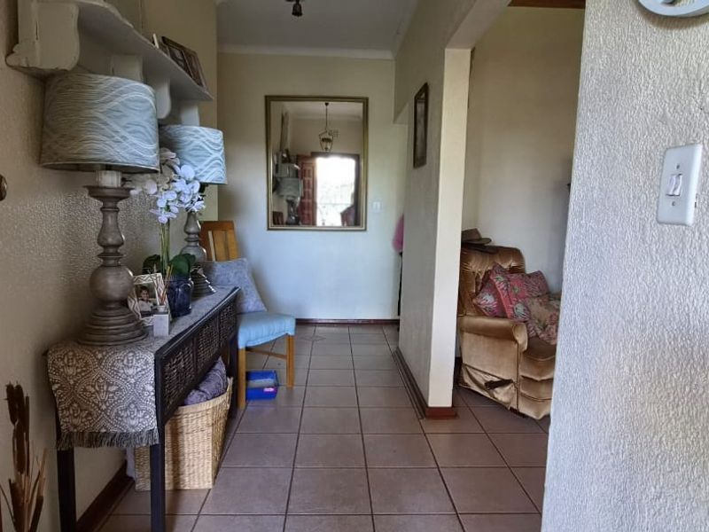 A functional entrance hallway featuring tiled flooring and an open archway leading into the adjacent living space.