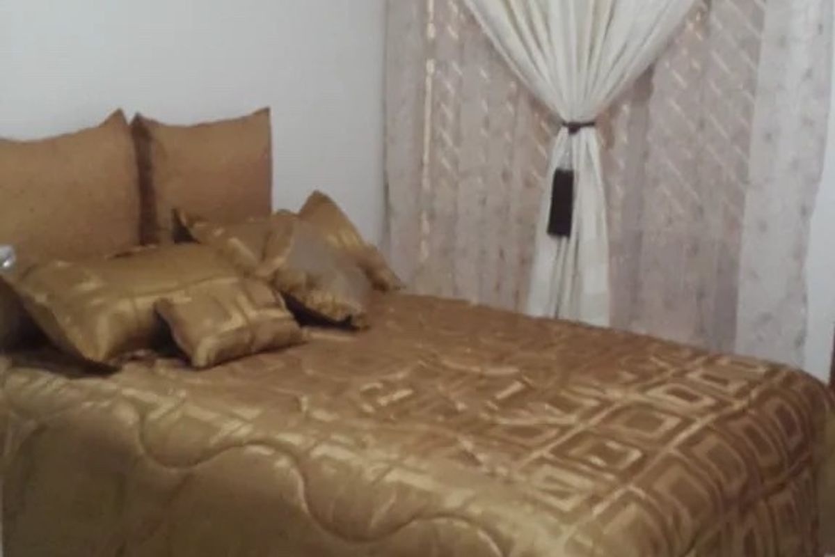 A bedroom featuring tiled flooring and a curtain rail, providing a functional space for rest.