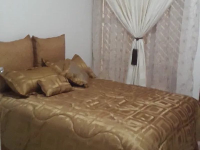 A bedroom featuring tiled flooring and a curtain rail, providing a functional space for rest.