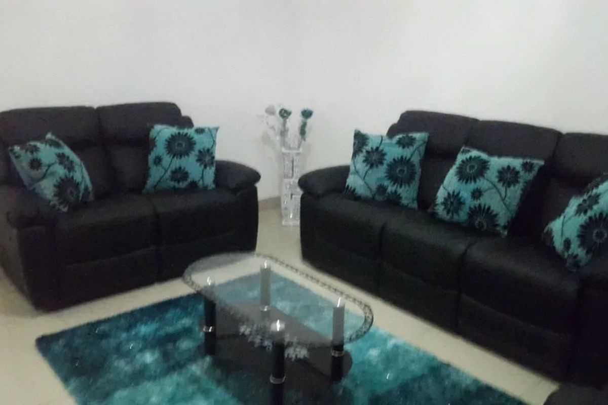 A living room area featuring neutral wall finishes and tiled flooring.