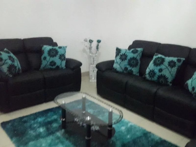 A living room area featuring neutral wall finishes and tiled flooring.