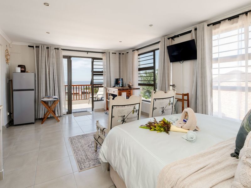 Spacious bedroom featuring tiled flooring, built-in cabinetry, and direct access to a private balcony with scenic views.