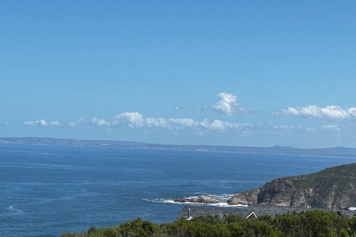 A scenic coastal view overlooking the ocean and rugged shoreline, showcasing the natural landscape and horizon.