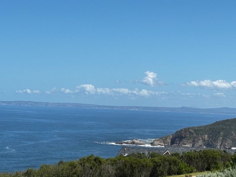 A scenic coastal view overlooking the ocean and rugged shoreline, showcasing the natural landscape and horizon.