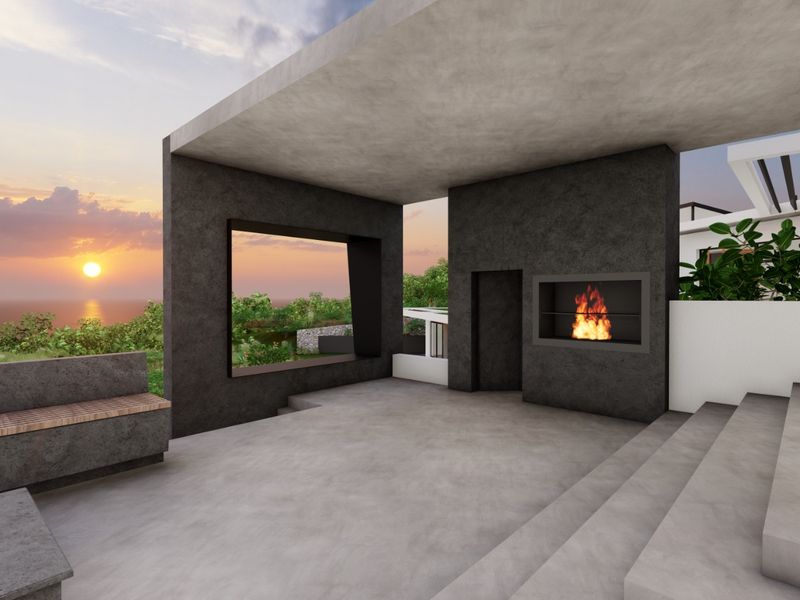 A modern covered patio featuring a built-in fireplace, concrete finishes, and panoramic sunset views, perfect for outdoor entertaining.