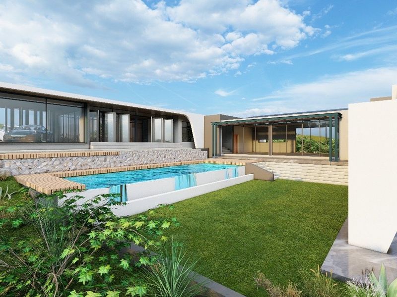 A modern architectural residence featuring a swimming pool, timber decking, stone retaining walls, and a landscaped garden area.