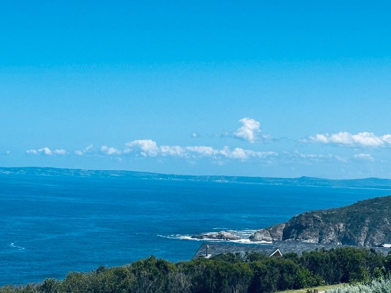 A scenic elevated view overlooking the ocean and rugged coastline, showcasing the natural beauty of the surrounding landscape.