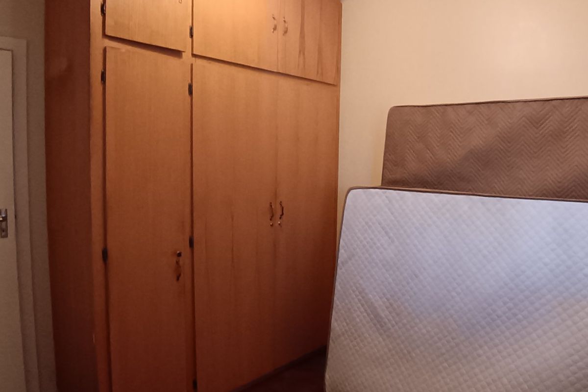A bedroom featuring built-in wooden cupboards, providing ample storage space within the room.