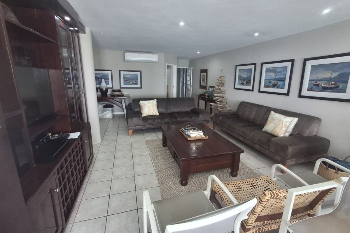 Spacious living room featuring tiled flooring, recessed downlighting, a built-in entertainment unit, and a wall-mounted split-system air conditioner.