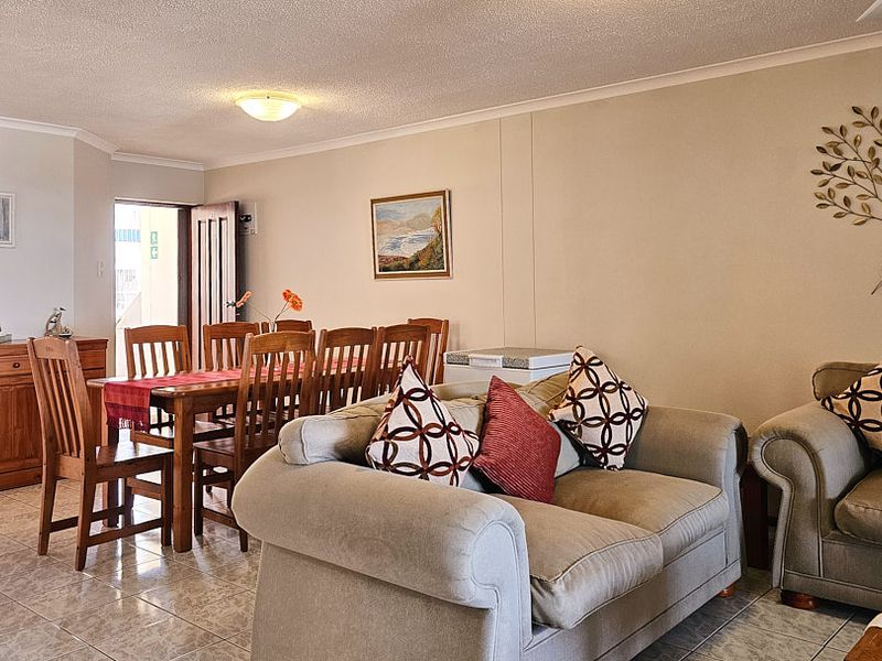 An open-plan living and dining area featuring tiled flooring and neutral wall finishes, providing a functional space for daily living and entertaining.