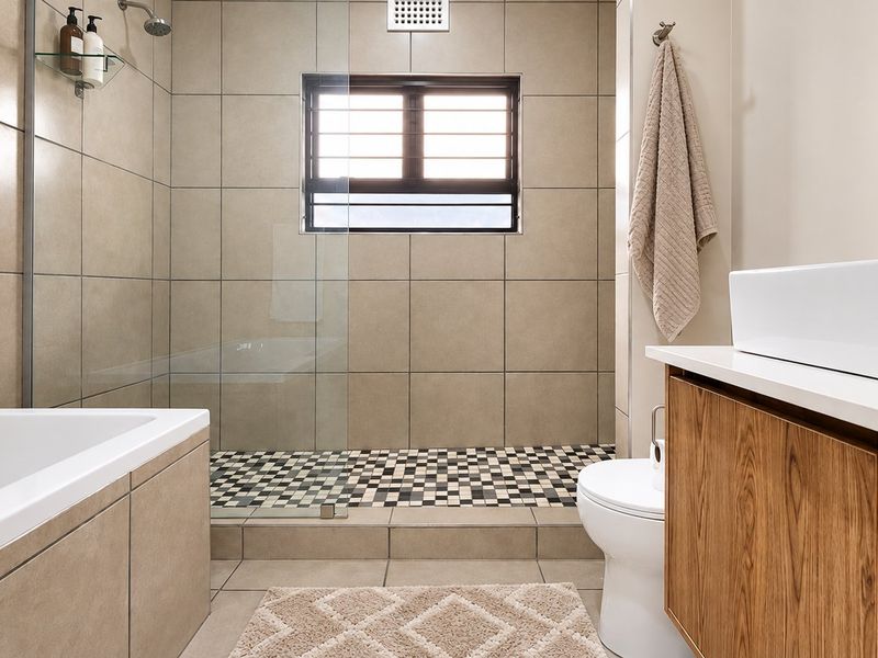 Modern bathroom featuring a built-in bathtub, a spacious walk-in shower with glass screen, and a contemporary vanity with a vessel sink.