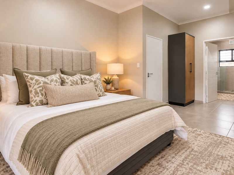 A well-appointed bedroom featuring neutral tones, built-in cabinetry, tiled flooring, and direct access to an en-suite bathroom.