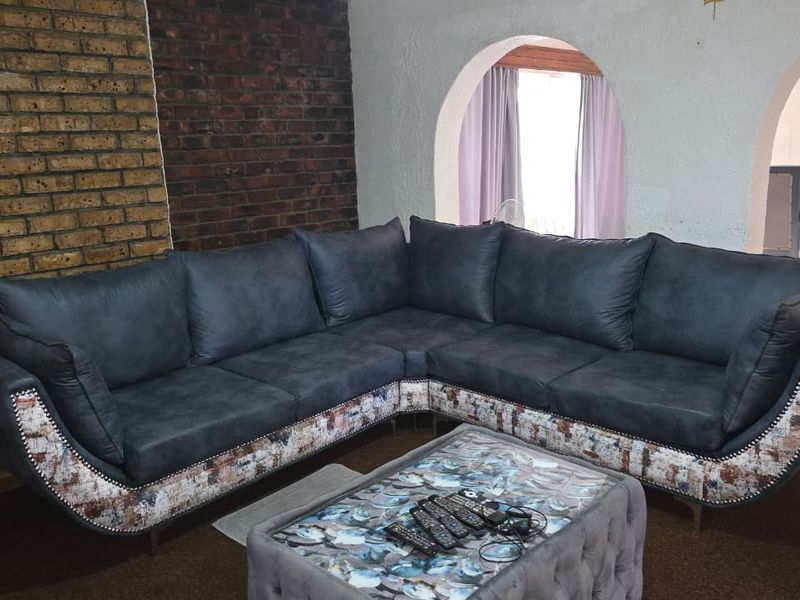A living room featuring a textured exposed brick feature wall and distinctive arched architectural openings leading to adjacent spaces.