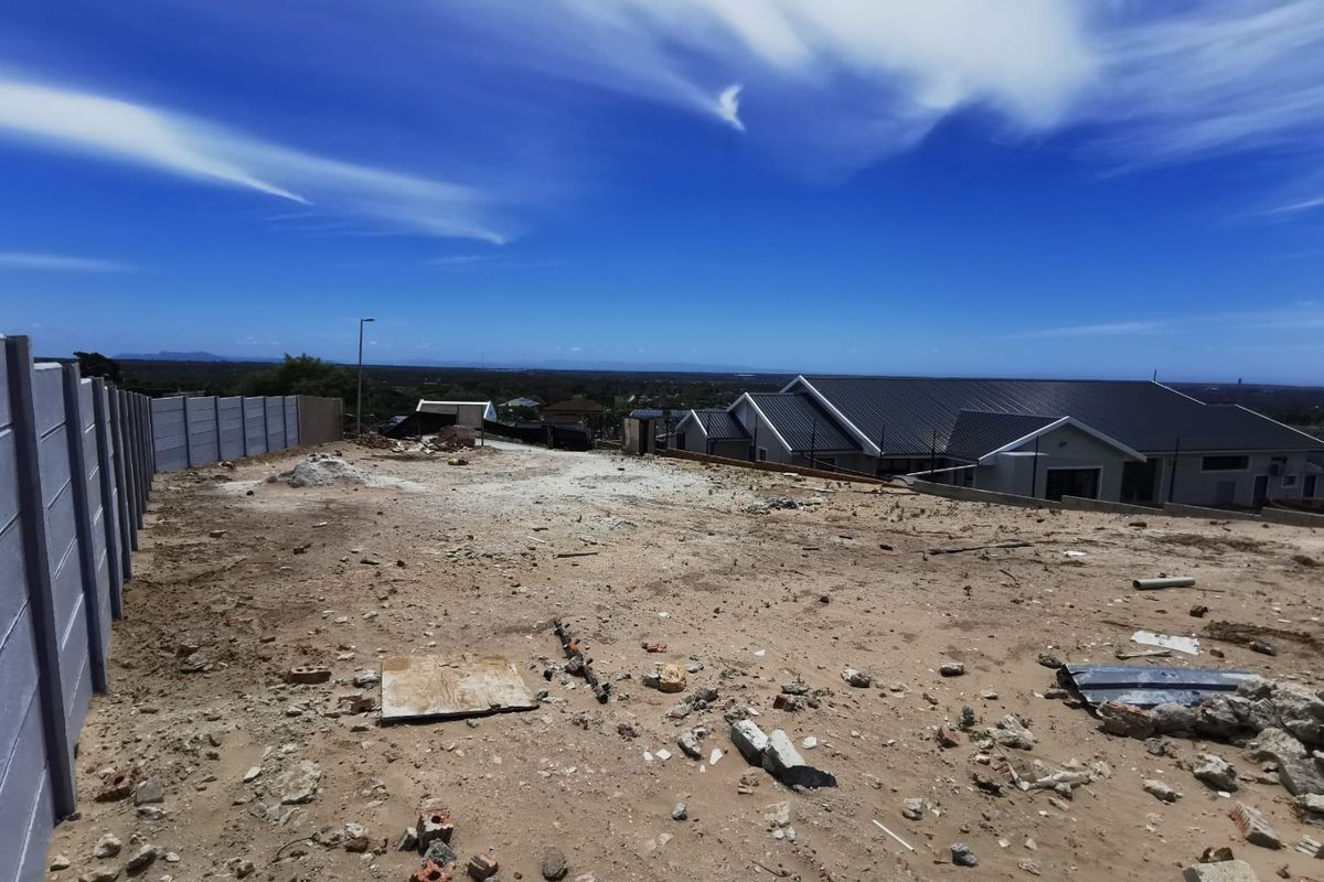 A vacant residential plot featuring a precast concrete boundary wall and views of the surrounding neighborhood.