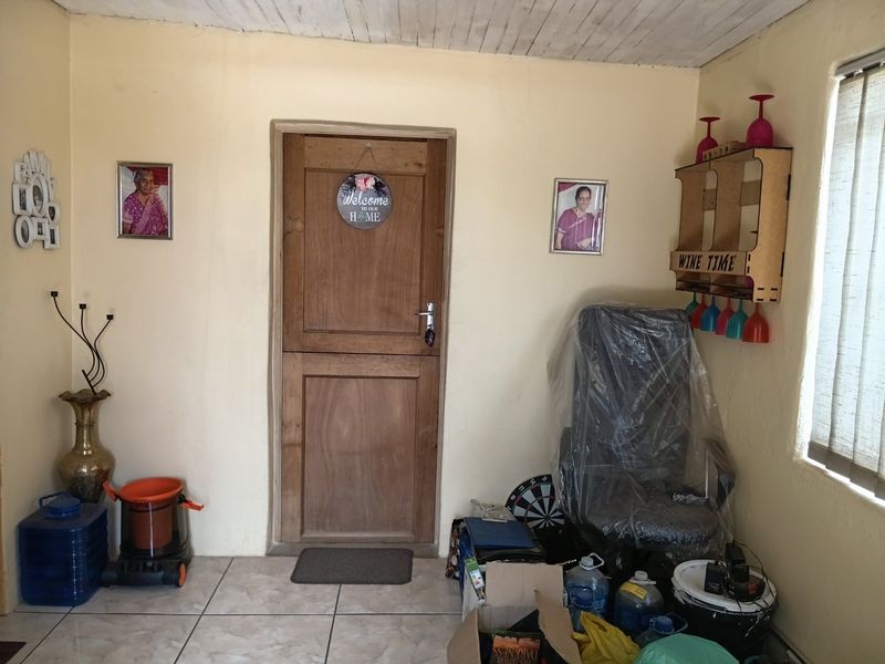 An entry area featuring a solid timber door, tiled flooring, and a timber ceiling, providing a functional access point to the home.