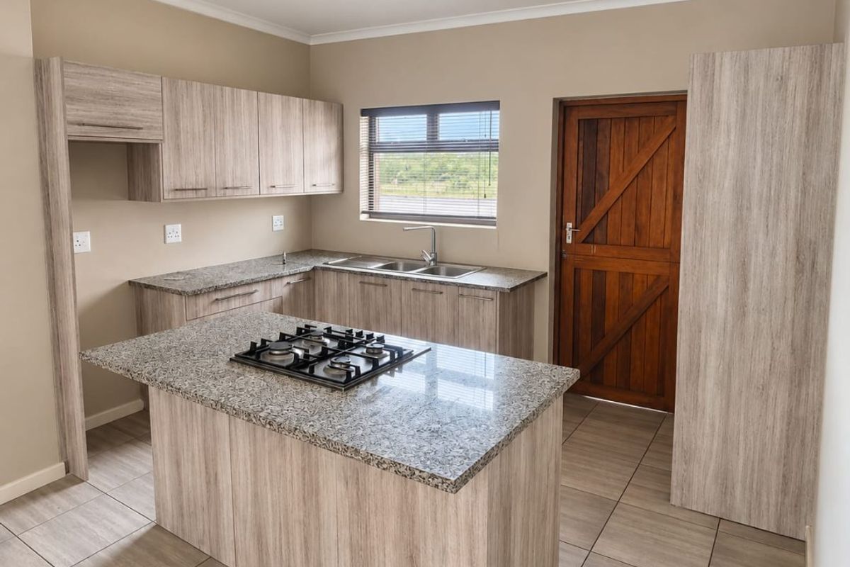 Modern kitchen featuring light wood-grain cabinetry, granite countertops, a central island with a gas hob, and tiled flooring.