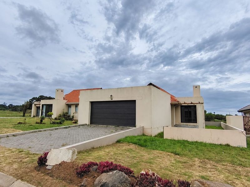 Front elevation of a single-story house featuring a double garage, paved driveway, and terracotta roof tiles set on a landscaped plot.
