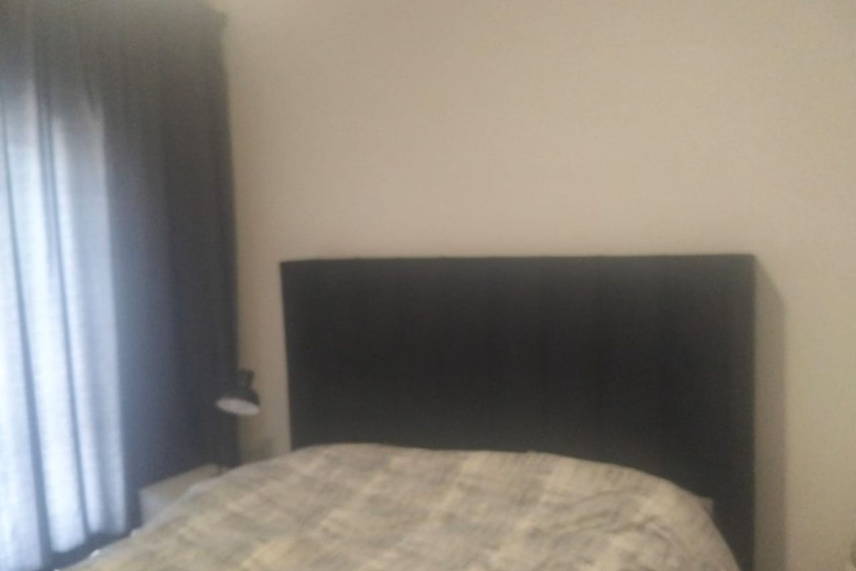 A bedroom featuring neutral wall finishes and window treatments.