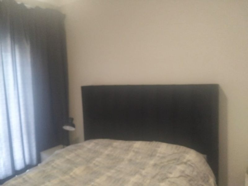 A bedroom featuring neutral wall finishes and window treatments.