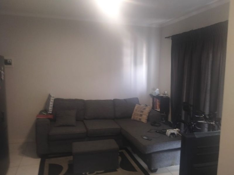 A living room area featuring tiled flooring and curtain rails, providing a neutral base for interior design updates.