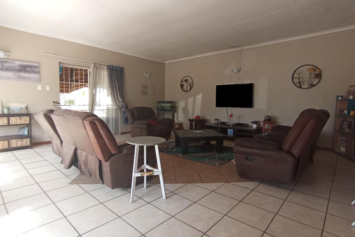 Spacious living room featuring neutral tiled flooring and a sliding glass door providing access to the outdoor area.