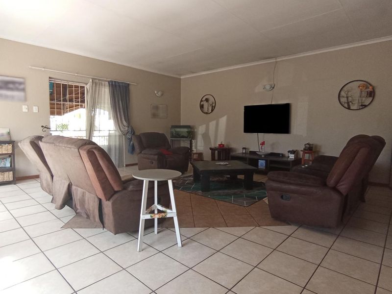 Spacious living room featuring neutral tiled flooring and a sliding glass door providing access to the outdoor area.