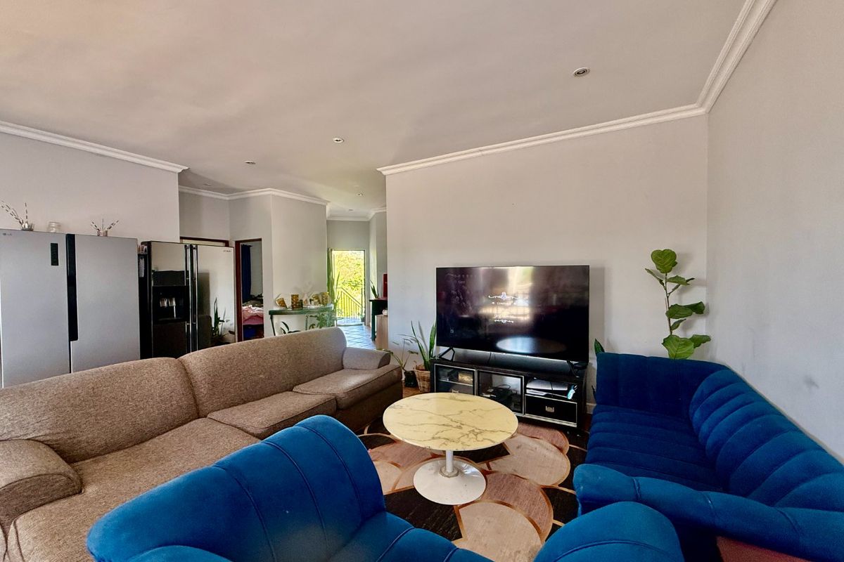 A spacious living room featuring recessed downlighting and decorative cove cornicing, providing a neutral foundation for comfortable family living.