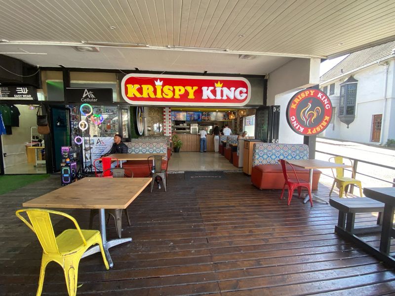 Commercial outdoor dining area featuring timber decking and a covered patio space, currently operating as a fast-food establishment.