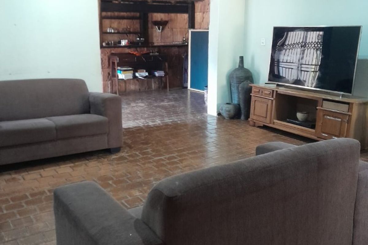 A living room featuring tiled flooring and recessed ceiling lighting, with an open transition to an adjacent secondary space.