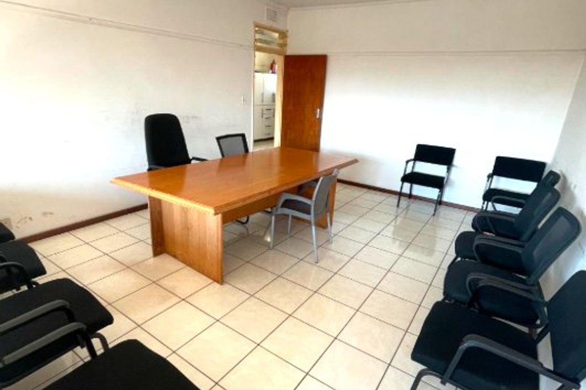 A functional office space featuring ceramic tiled flooring and fluorescent lighting, suitable for a meeting room or workspace.