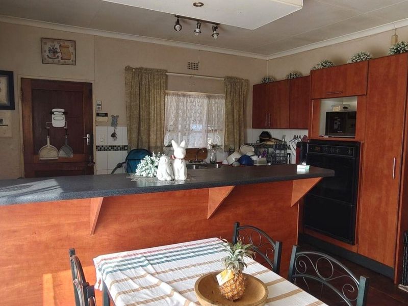 A functional kitchen featuring wood-tone cabinetry, a breakfast bar, and built-in appliances, offering a traditional layout with potential for modern updates.