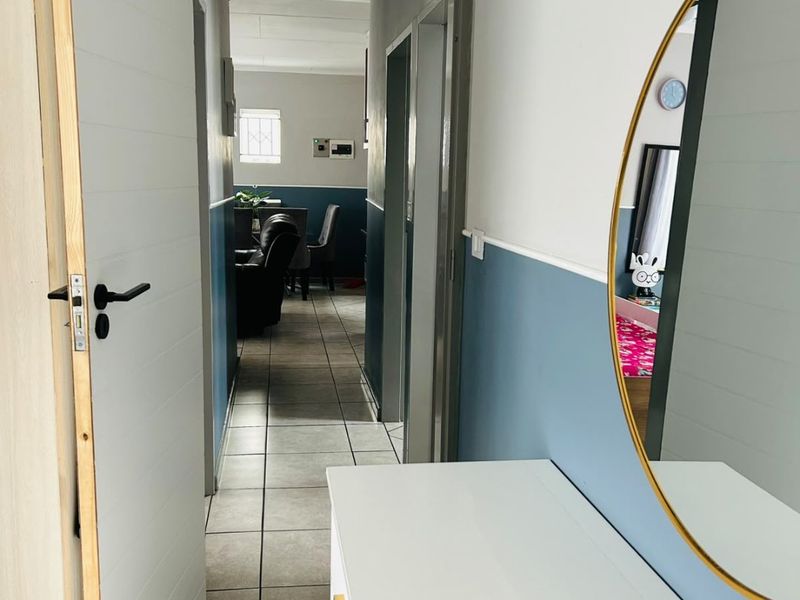 A bright hallway featuring tiled flooring and neutral wall finishes, providing a clear transition between the home's living spaces.