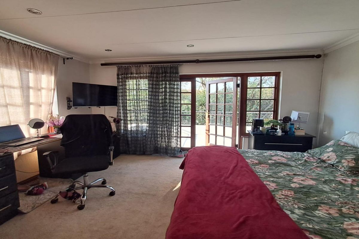 Spacious bedroom featuring carpeted flooring, recessed lighting, and direct access to an outdoor area through classic wooden french doors.