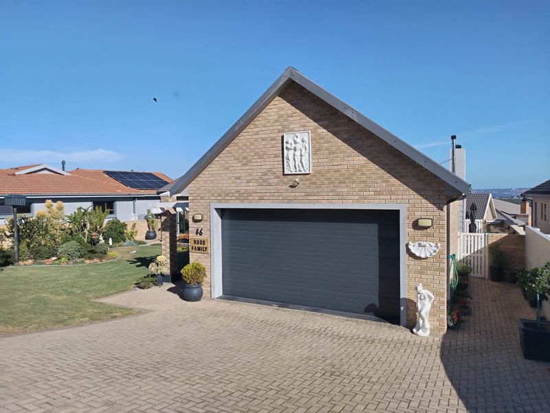 A well-maintained brick garage with a modern sectional door and paved driveway, situated in a neat residential setting.