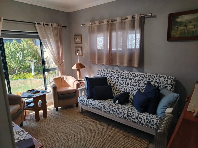 A cozy living room featuring a sliding glass door that provides natural light and direct access to the garden area.